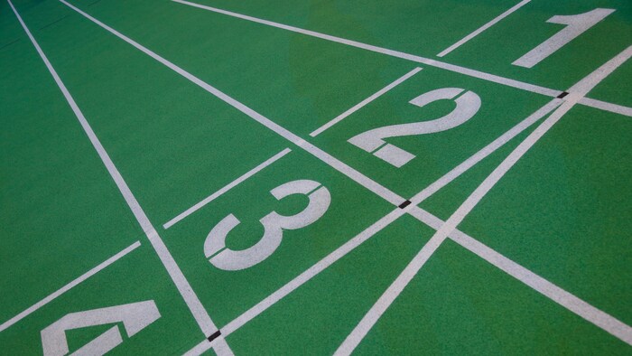 Numéros au sol des couloirs d'une piste d'athlétisme en salle