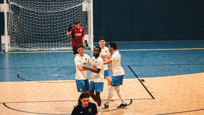 Des joueurs célèbrent un but pendant une rencontre de futsal.