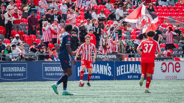 Des joueurs de soccer se passent le ballon pendant un match.