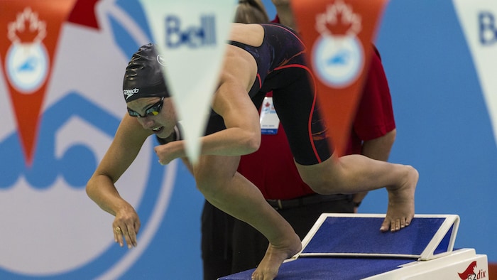 Une nageuse effectue un plongeon.