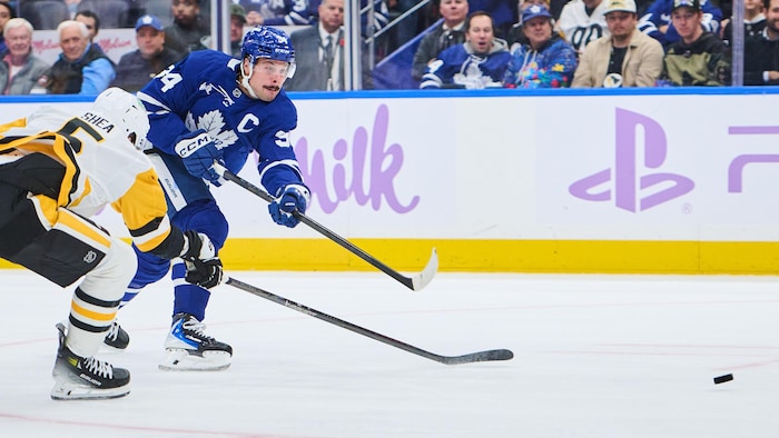 Un joueur de hockey effectue un lancer frappé.