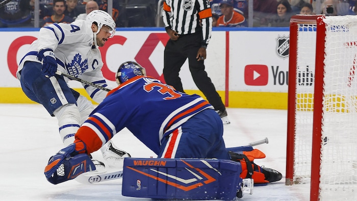 Un joueur de hockey déjoue un gardien.