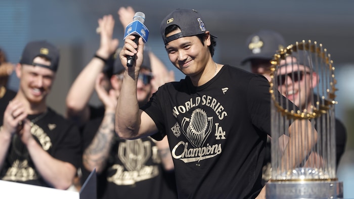 Un homme salue la foule aux côtés d'un trophée.