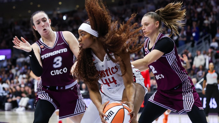 Des joueuses de basketball se battent pour le ballon.