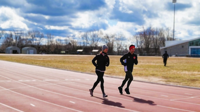 Deux coureurs sur une piste d'athlétisme.