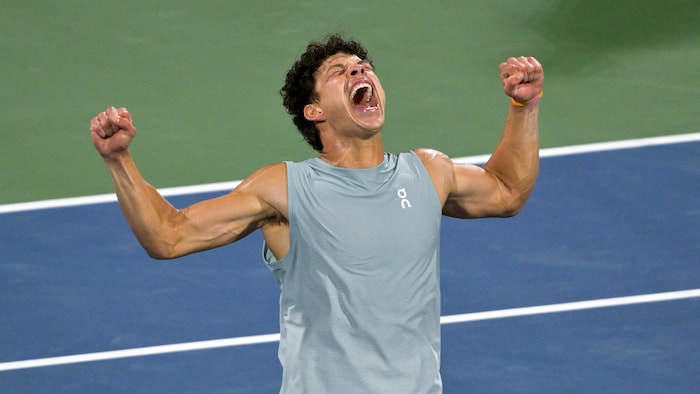 Un joueur de tennis crie de joie.
