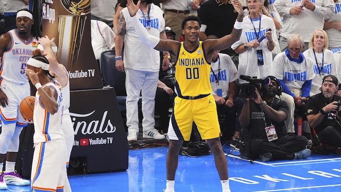 Un joueur en jaune, dépité, lève les bras.