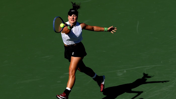 Une joueuse de tennis frappe un coup droit.