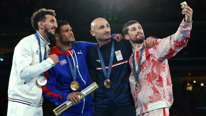 Sofiane Oumiha, Erislandy Alvarez Borges, ⁤Lasha Guruli, and Wyatt Sanford capture a moment together with a ⁤selfie on the catwalk.