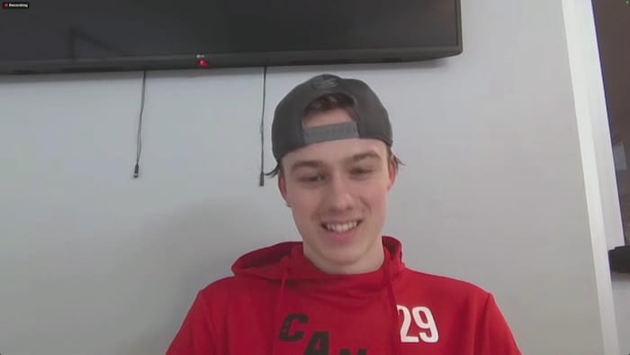 Un jeune homme souriant lors d'une vidéoconférence.
