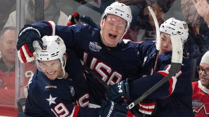 Trois joueurs de l'équipe des États-Unis célèbrent un but.