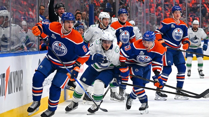 Des joueurs de hockey pourchassent la rondelle.