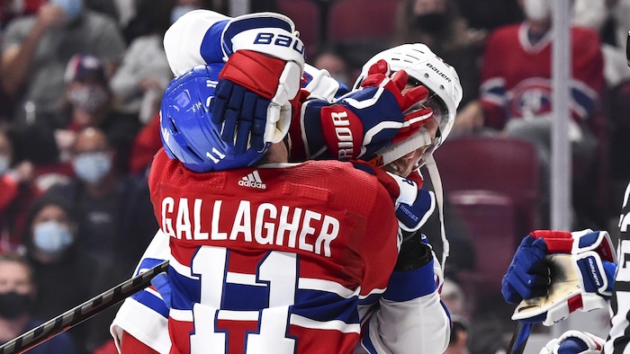 Deux joueurs se chamaillent sur la glace. 