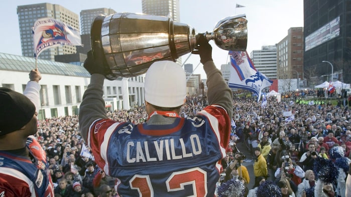 Il tient le trophée à bout de bras sur le podium à l'issue du défilé dans les rues de Montréal.