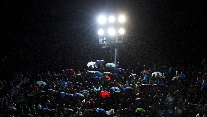 Des spectateurs sous la pluie.