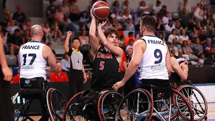 Garrett Ostepchuk, de l'équipe nationale canadienne de basketball en fauteuil roulant, tente une passe lors d'un match contre la France.