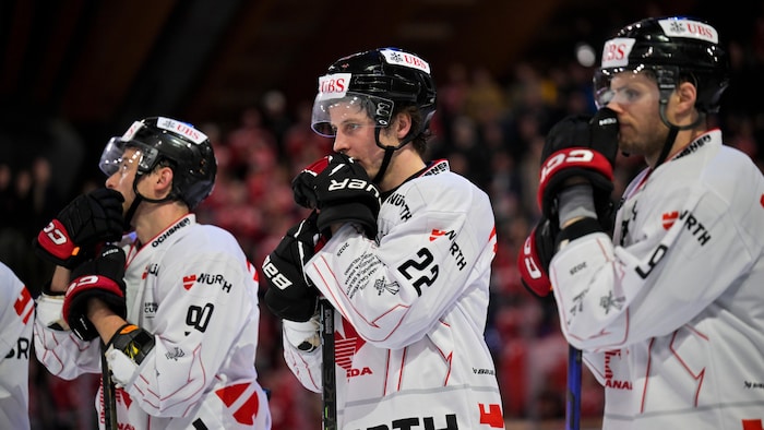 Trois hockeyeurs affichent un air déçu après une défaite.