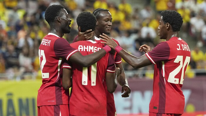 Des joueurs de soccer célèbrent un but.