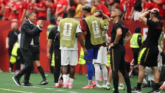 Des joueurs et membres du personnel semblent déçu du résultat.