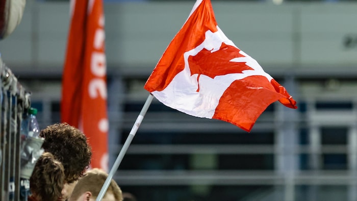 De jeunes partisans du Canada agitent leur drapeau.