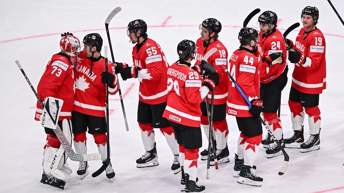 Des joueurs canadiens célèbrent leur victoire sur la glace.