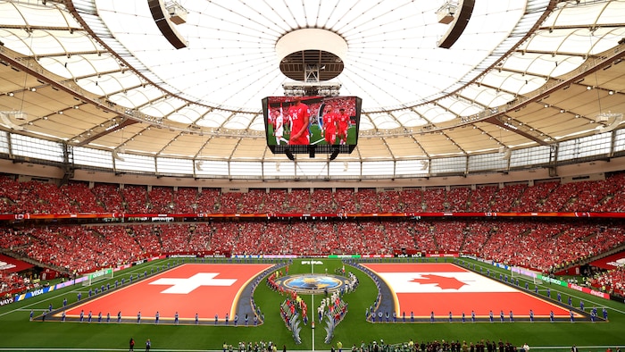 Plan large sur le stade. Les drapeaux de la Suisse et du Canada étendu sur la pelouse.