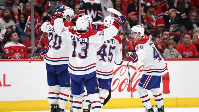 Des joueurs de hockey célèbrent un but.