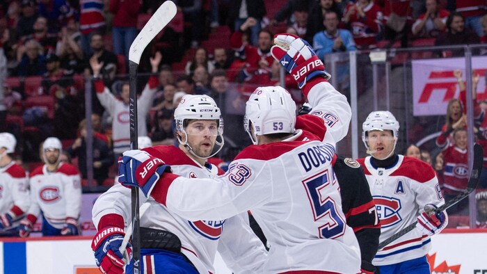 Des joueurs de hockey célèbrent un but.