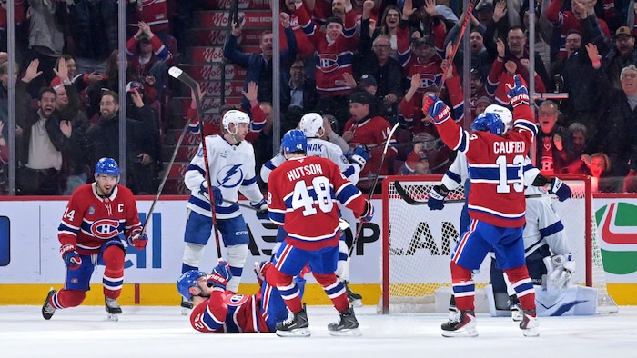 Des joueurs célèbrent un but devant des adversaires.
