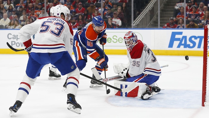 Un gardien de but est déjoué par le tir d'un adversaire devant lui. 