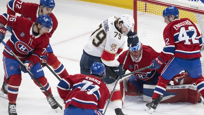 Un joueur de hockey devant un gardien et trois adversaires.