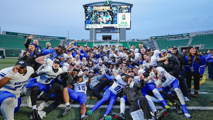 Les membres d'une équipe de football rassemblés ensemble dans un stade.