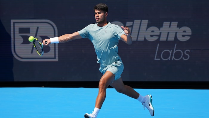 Un joueur de tennis s'apprête à frapper une balle d'un coup droit.