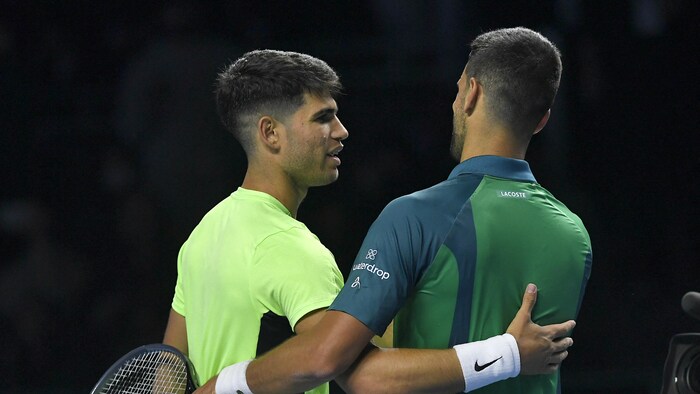 Deux joueurs de tennis se font l'accolade après un match.