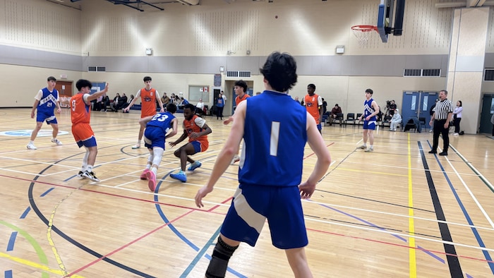 Player, from behind, watches a teammate be blocked by an opponent.