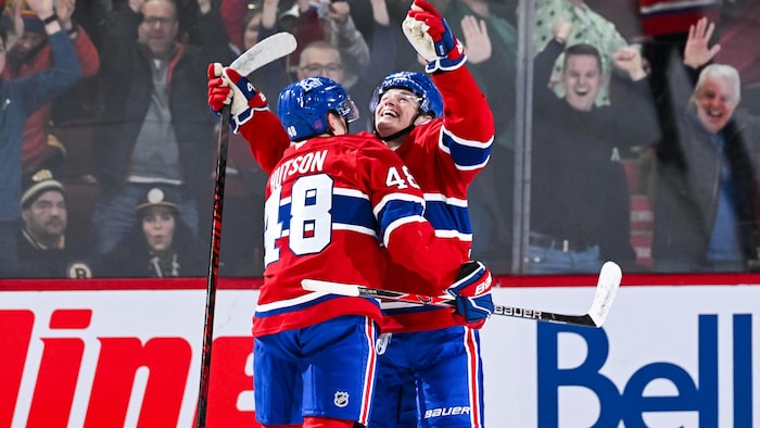 Deux joueurs célèbrent un but. 