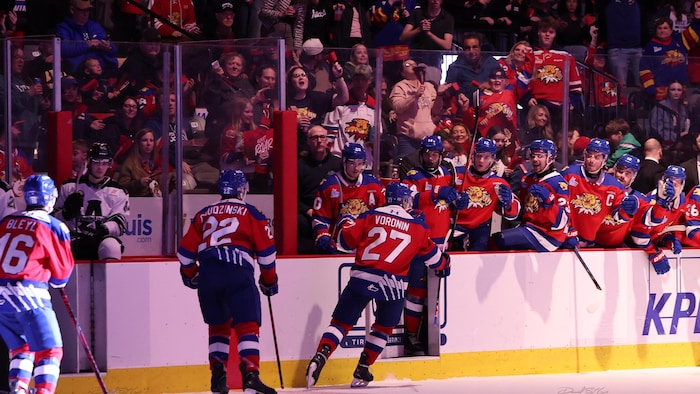 Joueur donnant la main aux joueurs sur le banc.