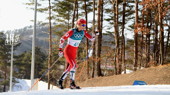 Une skieuse fait une montée.