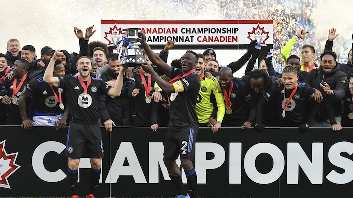 Des joueurs célèbrent leur championnat avec un trophée.