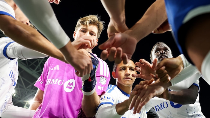 Des joueurs forment un cercle autour de lui.