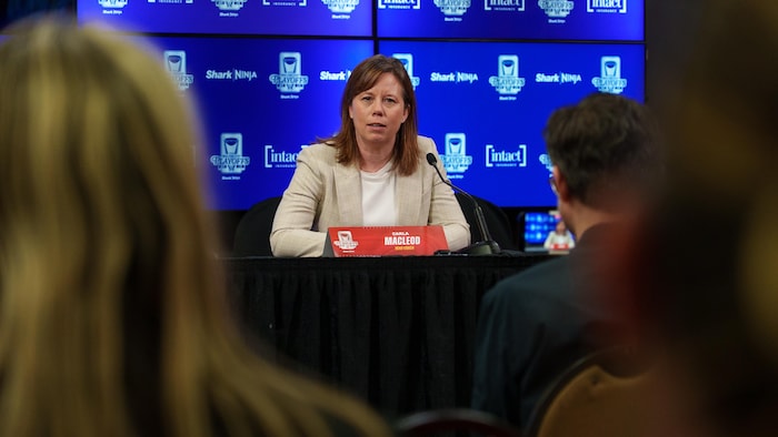 Une entraîneuse de hockey rencontre la presse après un match professionnel.
