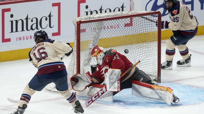 Une joueuse de hockey professionnelle déjoue la gardienne adverse pendant un match éliminatoire.