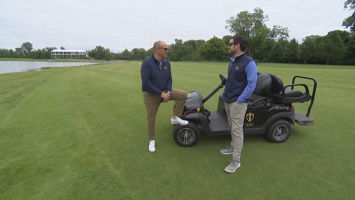 Ils discutent près d'une voiturette de golf.