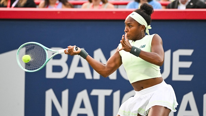 Une joueuse de tennis frappe un coup droit.