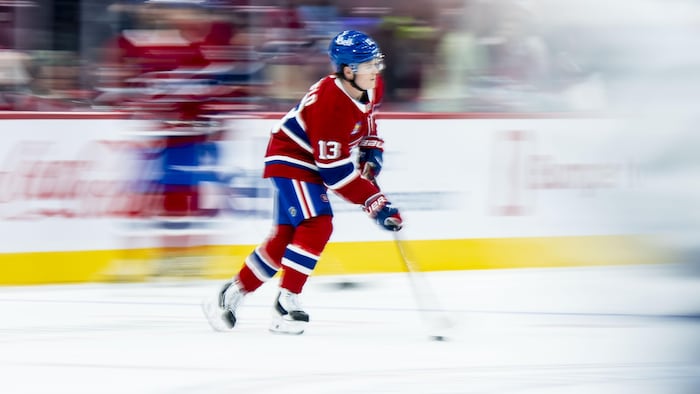 Une image floue d'un joueur de hockey en rouge qui transporte la rondelle.