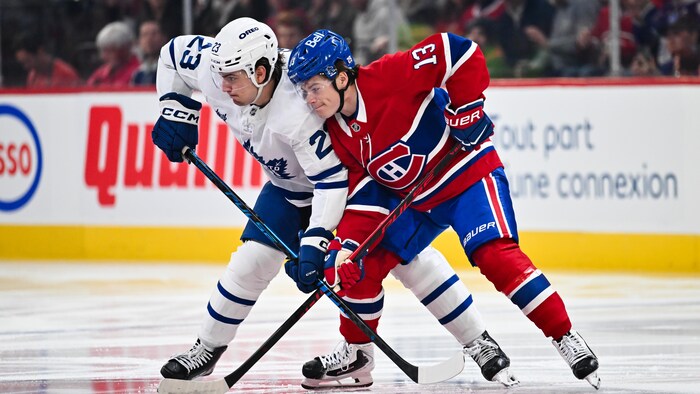 Deux joueurs de hockey croisent leurs bâtons.