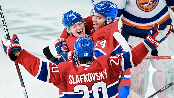 Un joueur de hockey célèbre un but avec ses coéquipiers.