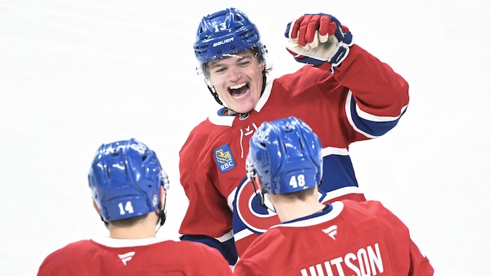 Trois hockeyeurs célèbrent un but.