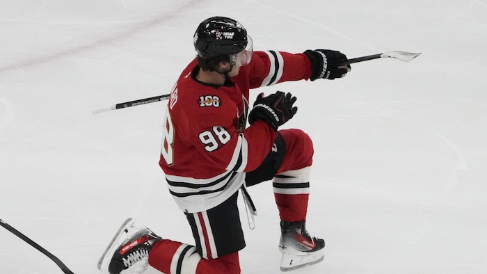 Un joueur de hockey célèbre un but sur la glace. 