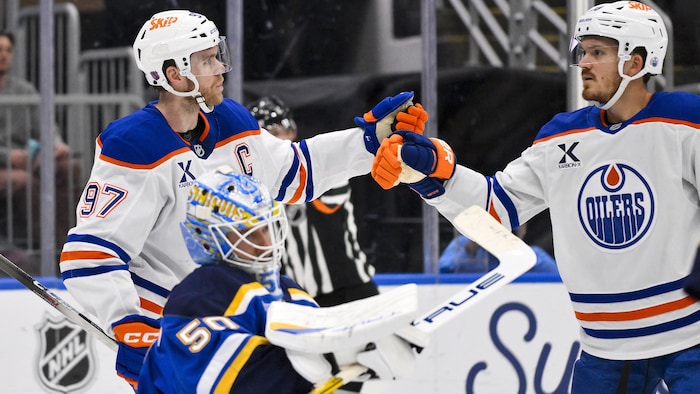 Deux joueurs de hockey se tapent dans la main.